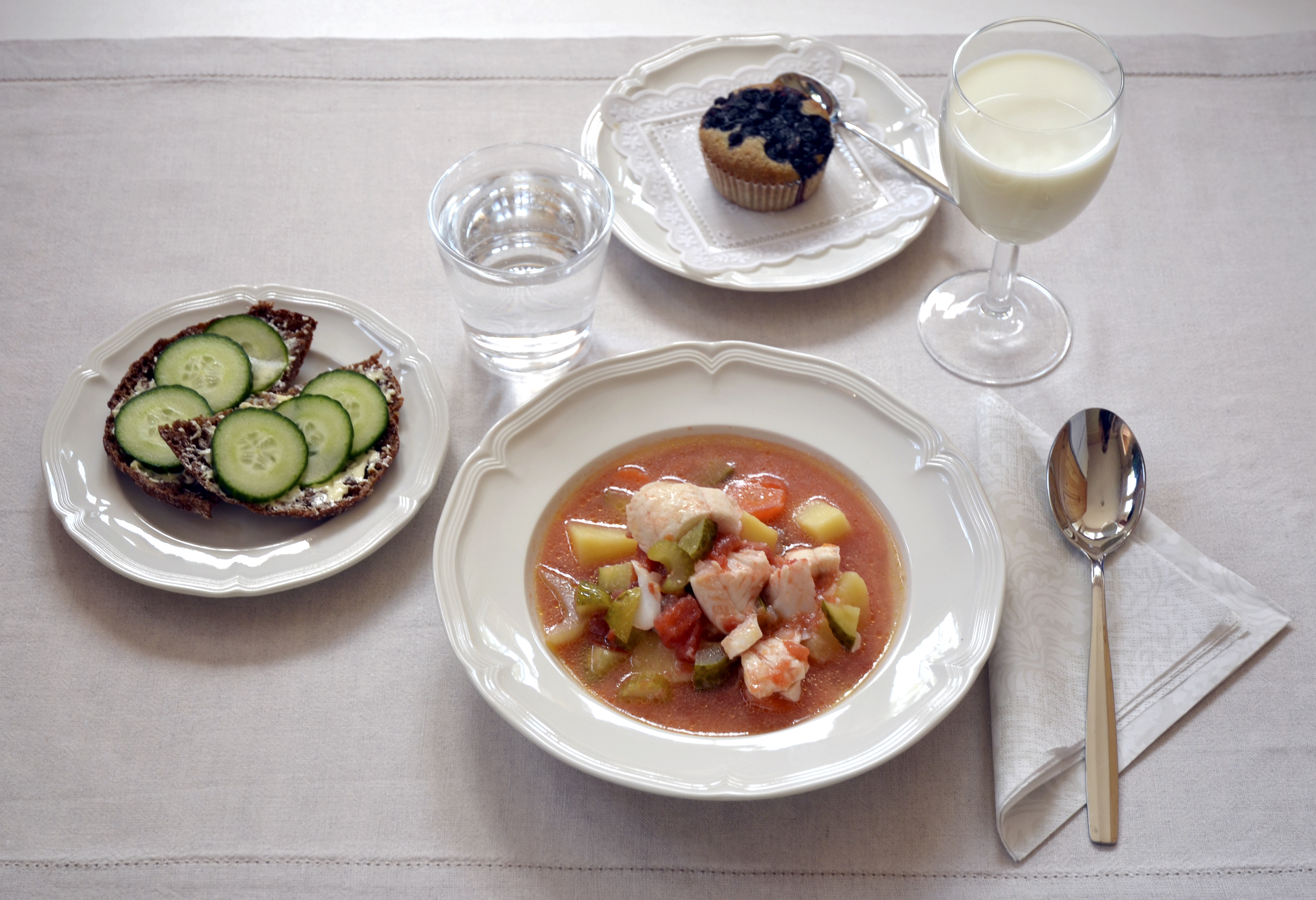 Kuvassa kalaseljankakeitto, ruisleipää, päällä levitettä ja kurkkua, vesi, mustikkamuffinssi, maito
