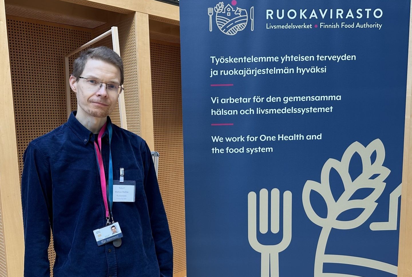 Mies seisoo Ruokaviraston mainoksen vieressä.